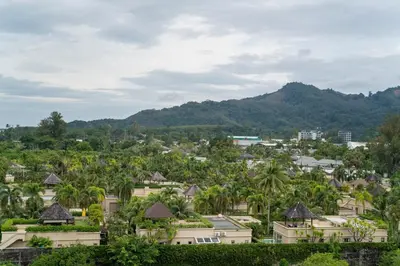 a city with palm trees and mountains in the background at Family Title Legendary 2Bdr Bang Tao in Bang Tao Beach