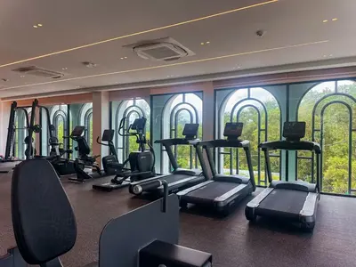 a gym with treadmills and ellipticals in front of windows at Family Title Legendary 2Bdr Bang Tao in Bang Tao Beach
