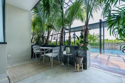 a patio with a table and chairs and a pool at Spacious beautiful studio with big patio on the pool side ! in Rawai Beach