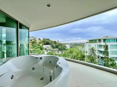 a bath tub in a bathroom with a large window at The Ark Karon Beach by RESAVA in Karon Beach