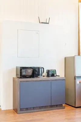 a microwave sitting on top of a counter next to a refrigerator at Harley 1 BDR Condo Kata Hill, 3 Mins To kata Beach in Kata Beach