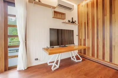 a room with a table with a television on a wall at Harley 1 BDR Condo Kata Hill, 3 Mins To kata Beach in Kata Beach