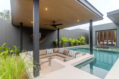 a patio with a couch next to a swimming pool at V263 Brand New 3BR Super Modern Pool Villa - Calathea in Thalang