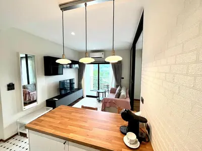 a kitchen and living room with a table and lights at MO607 1 br 36m in Nai Yang Beach
