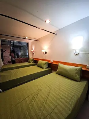 a room with two beds and a window at MT Friend Hostel Phuket Town in Phuket Town