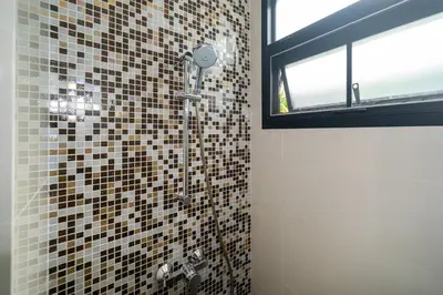 a bathroom with a shower with mosaic tiles on the wall at Luxury 5 bedroom villa Laguna Park in Laguna Phuket