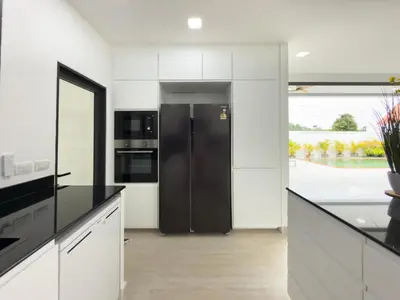 a kitchen with white cabinets and a black refrigerator at Stylish 3BR Pool Villa Lawan Villa (LWV1) in Phuket Town