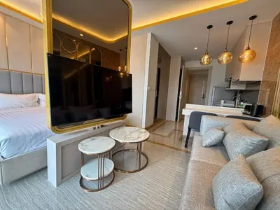a bedroom with a large flat screen tv and a couch at Bangtao Studio Bellevue Lagoon 6floor pool view in Laguna Phuket
