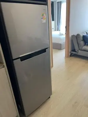 a refrigerator in a kitchen with a living room at The Ozone Condominium B130 Laguna in Laguna Phuket