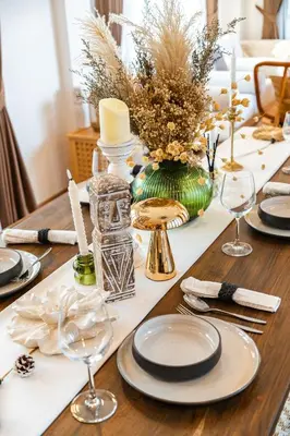 a table with plates and glasses on a wooden table at Phu Talae Villa Rawai Beach in Ban Klang