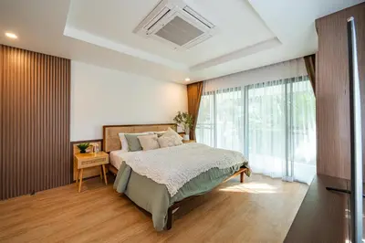 a bedroom with a bed and a large window at Phu Talae Villa Rawai Beach in Ban Klang