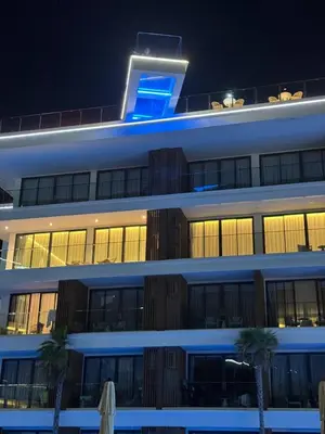 a building with a blue sign on top of it at Sunshine Beach, Kora Resort Phuket 5, Bang Tao, Laguna in Bang Tao Beach