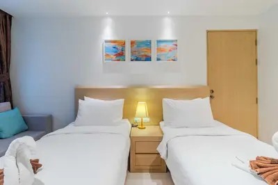 a bedroom with two beds and a night stand with a lamp at C245 Steps from the Beach Pool & Ocean View in Ban Saiyuan (1)