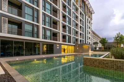 a swimming pool in front of a building at C246 New 1BR Condo with Pool, Gym &Great Location in Thalang