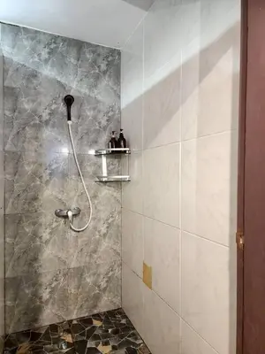 a shower with two people sitting on a shelf in a bathroom at The Rest Phuket in Phuket Town