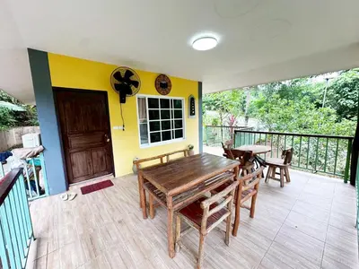 a room with a table and chairs on a balcony at Floresh Freedom Hostel in Phuket