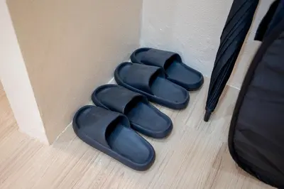 a pair of black slippers next to a wall at Amaleena Pool Access Suites in Ban Bang Chak