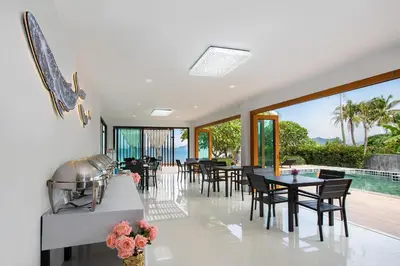a dining room with tables and chairs and a pool at Amaleena Pool Access Suites in Ban Bang Chak