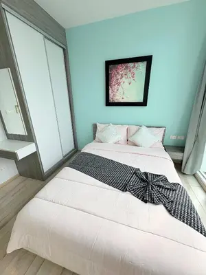 a white bed in a room with blue walls and windows at The closest accommodation next too central Mall in Ban Rangeng
