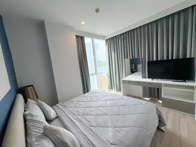 a bedroom with a bed and a desk with a television at The closest accommodation next too central Mall in Ban Rangeng