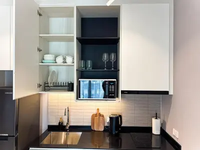 a kitchen with white cabinets and a microwave at Amazing 1Bdr Title Legendary Bang Tao in Bang Tao Beach