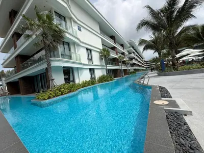 a swimming pool in front of a building at Sunshine BEACH FRONT in Layan Beach