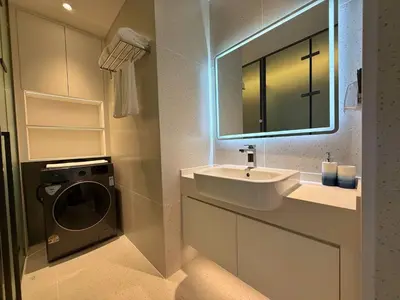 a bathroom with a sink and a washing machine at Sunshine BEACH FRONT in Layan Beach