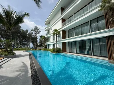 a swimming pool in front of a building at Sunshine BEACH FRONT in Layan Beach