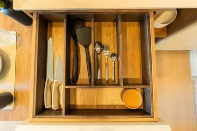 a wooden cabinet with utensils in it at 1BR near Laguna, Space Cherngtalay, Bangtao beach by Pat in Ban Thalat Choeng Thale