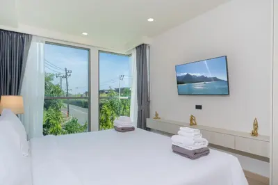 a bedroom with a large bed and a large window at Phuket Family apartment in Phuket Town