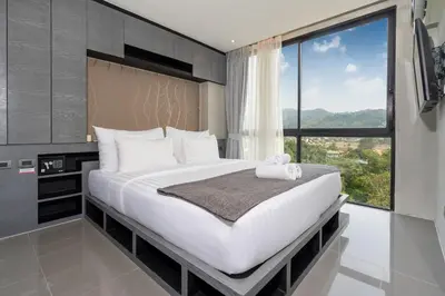 a bedroom with a large bed with a large window at 1BR Mountain View Condo Citygate P708 in Kamala Beach