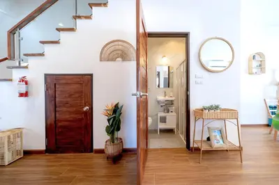 a hallway with a wooden door and a staircase at Holistic Haven Private Pool Villa at Kamala Newest Residence in Kamala Beach