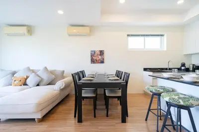 a living room with a couch and a table with chairs at Villa Mangosteen 3BR Seaview Pool and Rooftop in Ban Saiyuan (1)