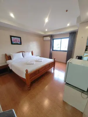 a bedroom with a large bed and a window at OYO Dynasty Hotel in Patong Beach