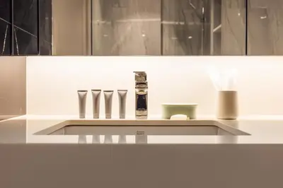 a white kitchen counter with a shelf with three knives at Suite Imola Gym Pool Close to Beach – Bellevue in Laguna Phuket