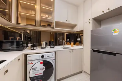 a kitchen with a washer and a dishwasher at Suite Avila 2BR Gym Pool Close to Beach in Laguna Phuket