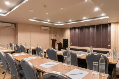a conference room with tables and chairs and a podium at Recenta Phuket Suanluang by Deevana in Phuket Town