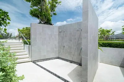 a stone shower in a bathroom with stairs at Beachside Residences 3 BR apartment by NLA in Bang Tao Beach