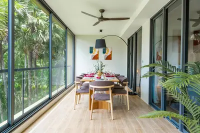 a dining room with a table and chairs and large windows at Beachside Residences 3 BR apartment by NLA in Bang Tao Beach
