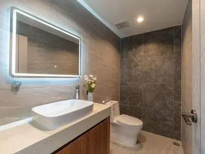 a bathroom with a sink and a toilet and a mirror at Lakeside 5-BR New Pool Villa in Gated Community in Chalong