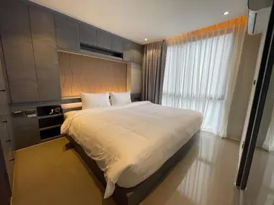 a bedroom with a large bed and a window at Popular Kamala City Gate 1 bdr 3 Pools in Kamala Beach