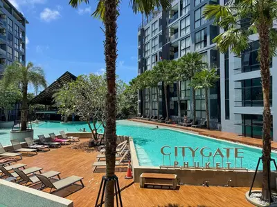 a swimming pool with chaise lounge chairs and palm trees at Popular Kamala City Gate 1 bdr 3 Pools in Kamala Beach