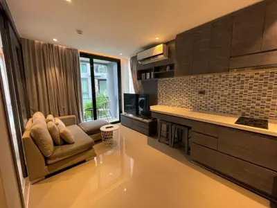 a living room with a couch and a kitchen at Cozy 1 Bdr City Gate Kamala Beach in Kamala Beach