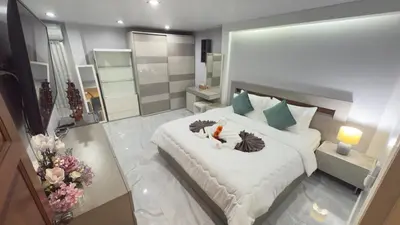 a bedroom with a large bed with two birds on it at Family House Patong - Homestay in Patong Beach