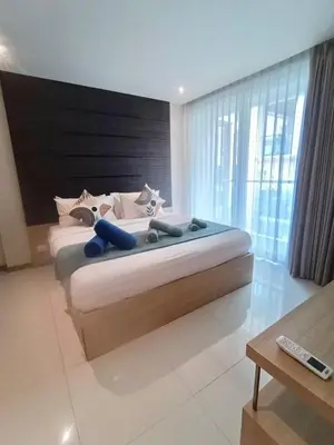 a bedroom with a large bed with a large window at The Bay Cliff Kalim 1 Large Bedroom by ALL HOMES in Patong Beach