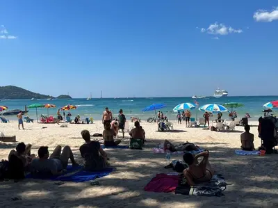 a group of people sitting on the beach at SSS Room Patong in Patong Beach
