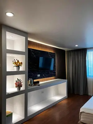 a living room with a tv on a wall at SSS Room Patong in Patong Beach