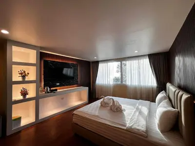a bedroom with a bed with a television on the wall at SSS Room Patong in Patong Beach