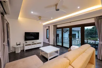 a living room with a couch and a flat screen tv at 2,5BR Tropical Lakeview Villa I Bangtao Beach in Surin Beach