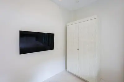 a tv on a wall next to a white cabinet at Nua Tone Pool Villa I Mountain View I Bangtao Beach in Ban Thalat Choeng Thale